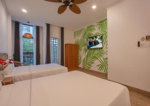 a bedroom with two beds and a ceiling fan at Khách sạn gần biển Viva Tuy Hoà Phú Yên in Phường Sáu