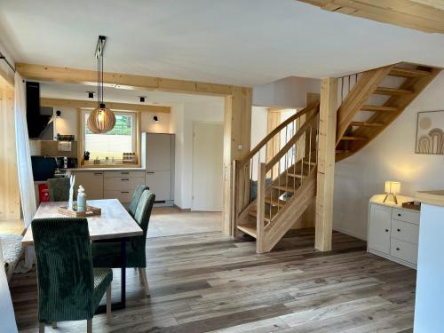 a kitchen and dining room with a table and a staircase at Urlaub am Schwarzbach mit Sauna und Whirlpool Haus Johanna in Butgenbach