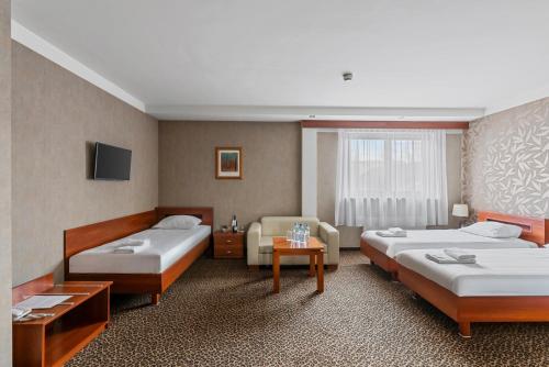a hotel room with two beds and a television at Hotel Diament Vacanza Katowice - Siemianowice in Siemianowice Śląskie