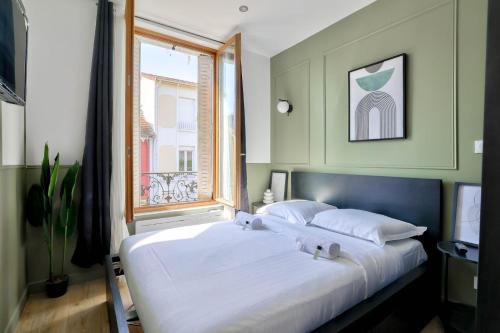 une chambre avec un grand lit blanc avec une fenêtre dans l'établissement GuestReady - Charm and Comfort near Paris, à Bagneux