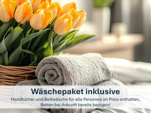 einen Strauß orangefarbener Tulpen in einem Korb neben einem Handtuch in der Unterkunft Ferienhaus mit Reetdach Gerdi in Heringsdorf