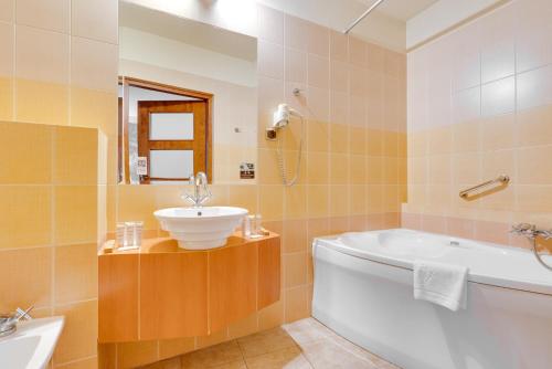 a bathroom with a white tub and a sink at Hotel Diament Vacanza Katowice - Siemianowice in Siemianowice Śląskie