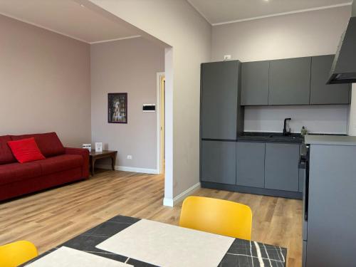 a kitchen and a living room with a red couch at Le Vele Rooms - Trieste Reception in Trieste