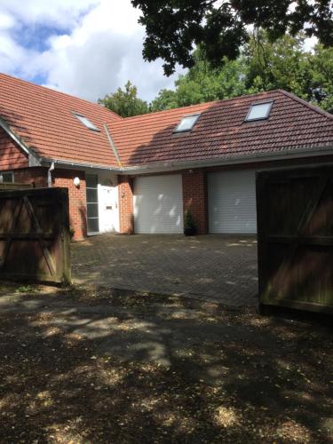 a house with two garage doors and a driveway at Hillhouse in Hythe