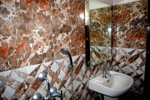 La salle de bains est pourvue d'un lavabo et d'un miroir. dans l'établissement Blooming Star Guest House, à Mandarmoni