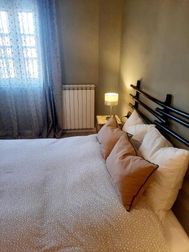 a bedroom with a large bed with pillows and a window at A casa di Milo in Prato