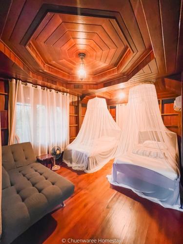 a living room with two beds and a couch at Chuenwaree Riverside Stay in Suratthani