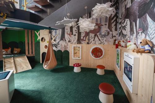 a childrens play room with a mural of a forest at Kompleks Antałówka Termy & Med in Zakopane