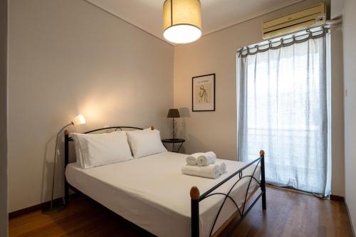 a bedroom with a bed with white sheets and a window at Seaside Escape in Kalamata