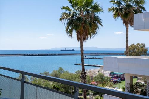 a view of the water from a balcony with palm trees at Seaside Escape in Kalamata