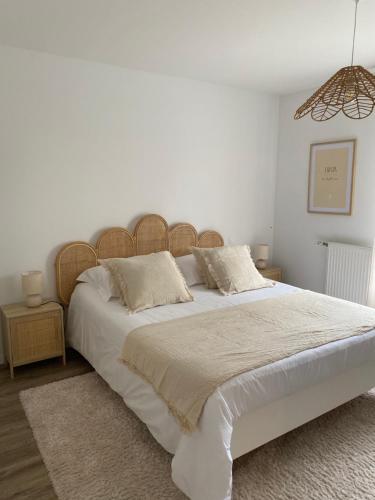 une chambre avec un grand lit avec des draps et des oreillers blancs dans l'établissement Le Lanroz beau T2 dans résidence privée Lambezellec, à Brest