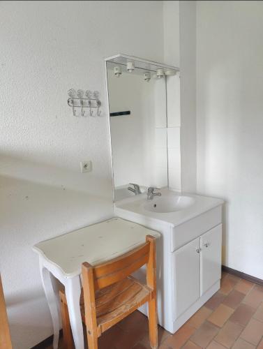 La salle de bains est pourvue d'un lavabo, d'une table et d'un miroir. dans l'établissement Hostel du Canyon, à La Palud-sur-Verdon