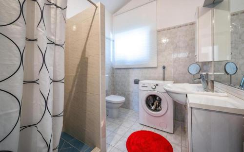 Un baño con lavadora y lavabo. en Apartment Percan, en Premantura