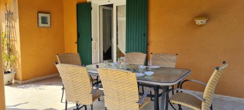 een houten tafel en stoelen op een terras bij Maison Gorges du Gardon in Collias