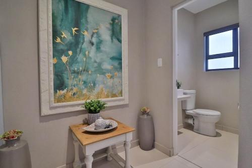 内尔斯普雷特Perfect Hideaway的一间带卫生间的浴室和墙上的绘画
