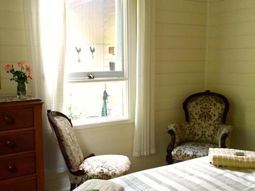 a bedroom with two chairs and a window at Alexandra Farmstay in Alexandra
