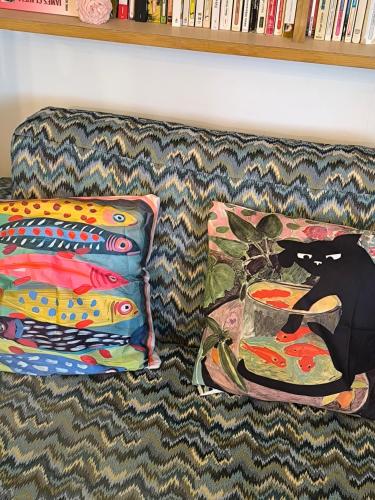 two pillows sitting on a couch next to a book shelf at Liège centre 6 rue montagne sainte Walburge, 4000 Liège, pour 2 pers à 3 minutes de la gare st Lambert in Liège