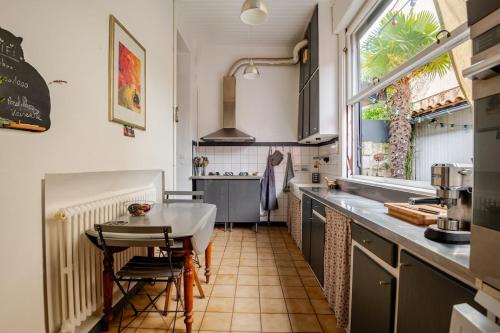 une cuisine avec une petite table et une cuisine avec une fenêtre dans l'établissement L'échoppe de Sophie, à Le Bouscat