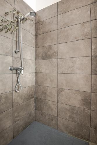 La salle de bains est pourvue d'une douche et d'un mur en pierre. dans l'établissement L'échoppe de Sophie, à Le Bouscat