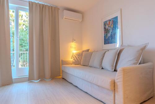 a living room with a white couch and a window at Villa Yadranka with Sea view in Strunjan