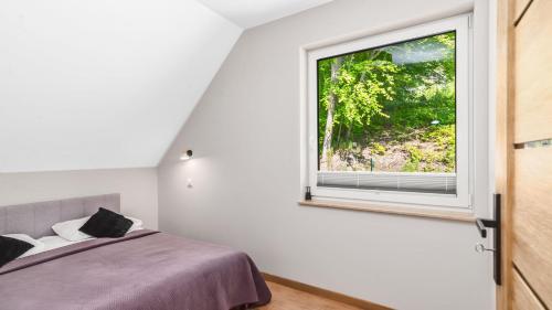 a bedroom with a bed and a window at Apartament pod Bukiem in Ostrzyce
