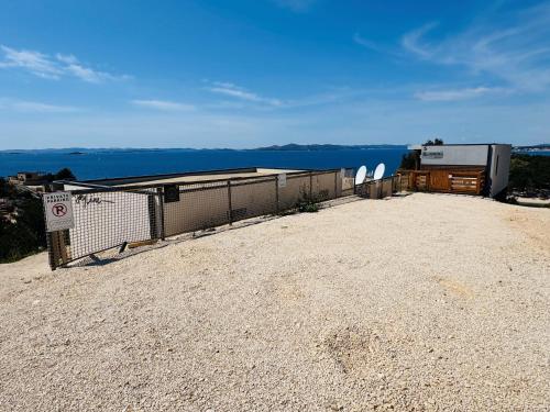 a building with a fence and the ocean in the background at Serenity Mobile House in Drage