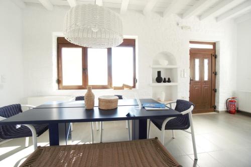 a blue dining room table with chairs and a chandelier at Villa Ikaros in Agia Triada