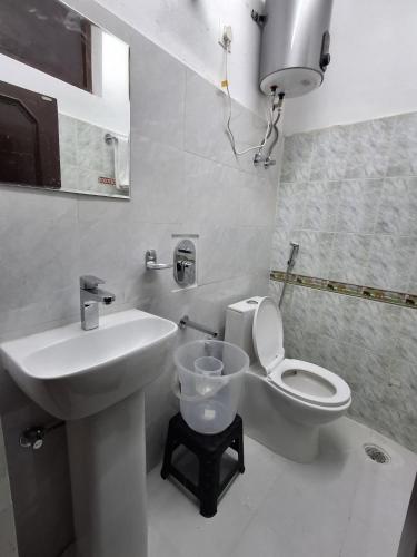 a white bathroom with a sink and a toilet at Just Us in McLeod Ganj