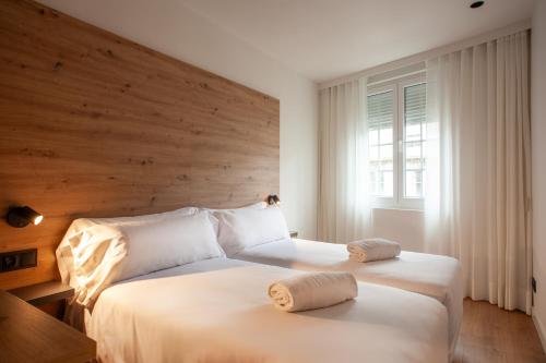 a bedroom with a large white bed with a wooden headboard at Plaza Obradoiro Express by Bossh! Hotels in Santiago de Compostela