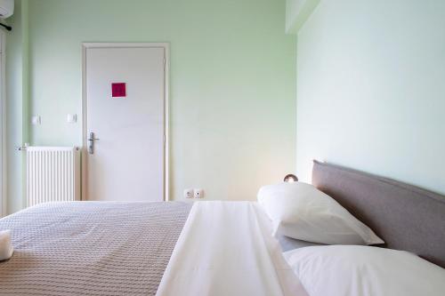 a bedroom with a bed with white sheets and pillows at Aris123 by Smart Cozy Suites - Apartments in the heart of Athens - 5 minutes from metro - Available 24hr in Athens