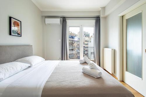 a bedroom with a large bed with towels on it at Aris123 by Smart Cozy Suites - Apartments in the heart of Athens - 5 minutes from metro - Available 24hr in Athens