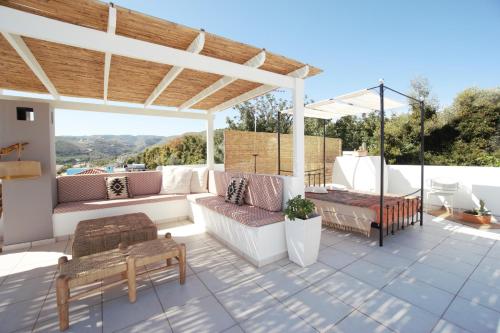 a patio with couches and a pergola at Villa Ikaros in Agia Triada