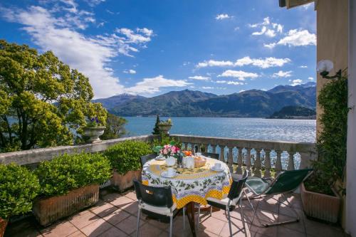 a table on a balcony with a view of the water at Villa Margherita Grande in Griante Cadenabbia