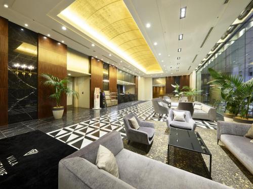 a lobby with couches and chairs and plants at Hotel Villa Fontaine Grand Tokyo-Roppongi in Tokyo