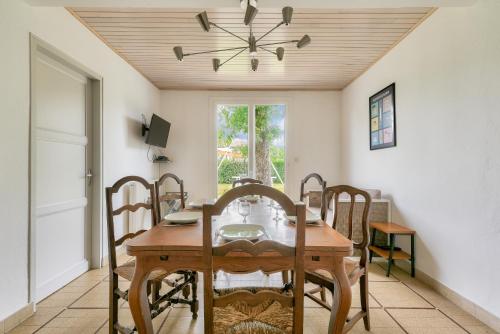 une salle à manger avec une table et des chaises en bois dans l'établissement Maison de vacances familiale proche de la plage, à Andernos-les-Bains