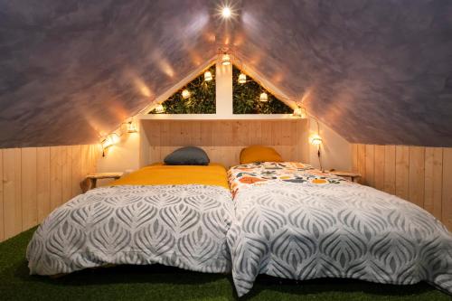 two beds in a small room with a roof at La Cabane - deux chambres et grande terrasse in Metz