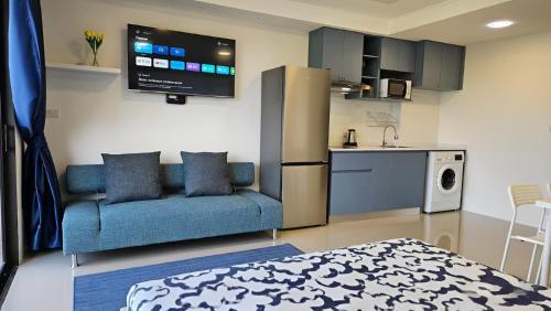 a living room with a blue couch and a kitchen at СС619 Романтика, чудесный вид и домашний уют in Mai Khao Beach