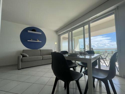 un salon avec une table, des chaises et un canapé dans l'établissement Appt Studio LA ROCHELLE - LR110-F13, à La Rochelle
