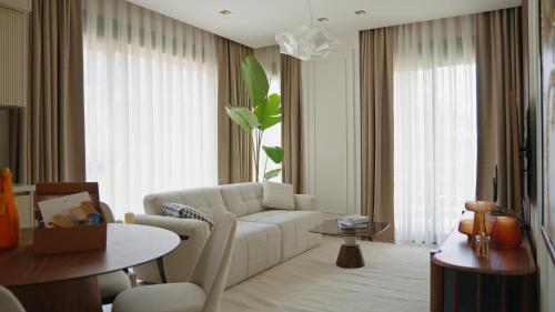 a living room with a white couch and a table at Qoople Legend B - premium apartments steps from the sea in Alanya
