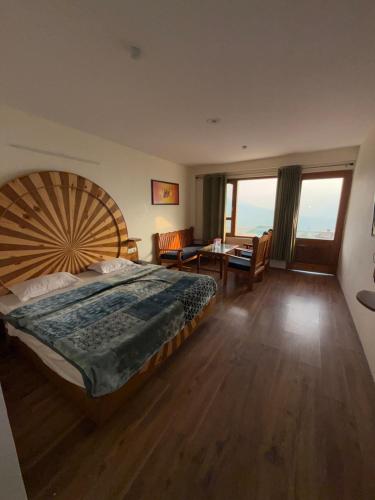 a bedroom with a large bed and a table at Cedar Valley Retreat in Jagatsukh