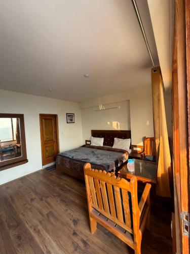 a bedroom with a bed and a bench in it at Cedar Valley Retreat in Jagatsukh