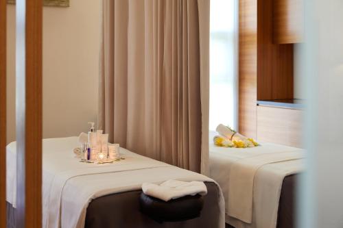 a room with two beds with towels on them at WE Hotel Jeju in Seogwipo