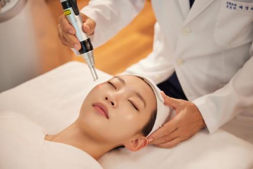 a woman in a spa getting her face laser treatment at WE Hotel Jeju in Seogwipo