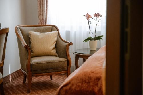 a room with a chair and a table and a window at Hotel City Central in Vienna