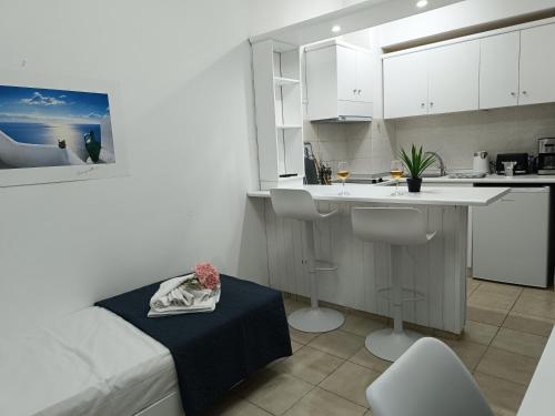 a kitchen with white cabinets and a table in a room at Nautilus City Studios & Apartments in Rhodes Town