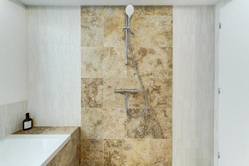 a shower with a shower head in a bathroom at NOCNOC - Maison Louise in Lyon