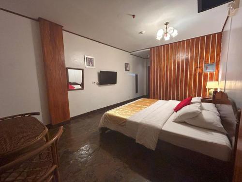 a bedroom with a bed with a wooden wall at Curv Hotels minutes to Airport- Malls in Puerto Princesa City