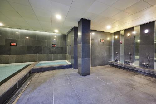 a bathroom with a swimming pool and urinals at WE Hotel Jeju in Seogwipo