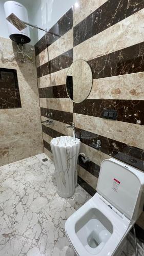 a bathroom with a white toilet in a room at Hotel Rising Star in Pushkar