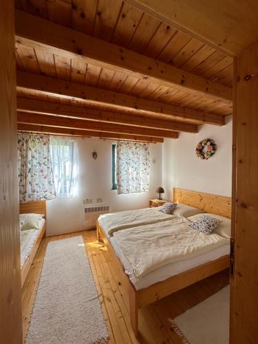 a bedroom with two beds and two windows at Chatka 428 a 429 - Tatralandia in Liptovský Mikuláš